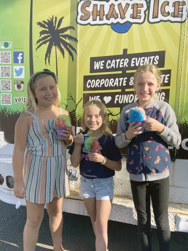 Three girls holding shave ice at a fundraiser
